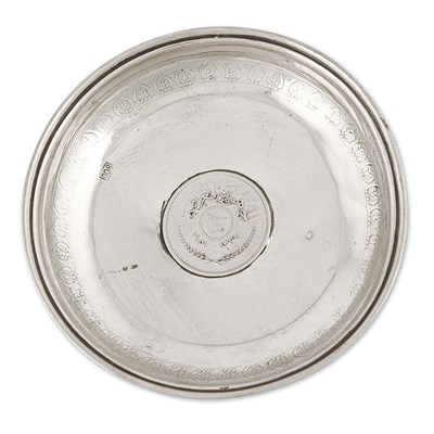 Circular silver dish with silver coin